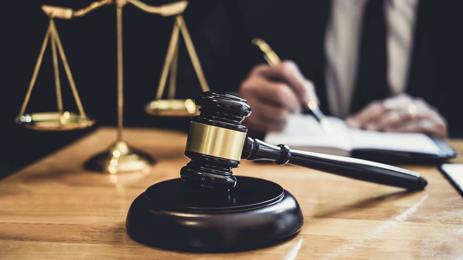 Balança da justiça e martelo sobre a mesa de um advogado
